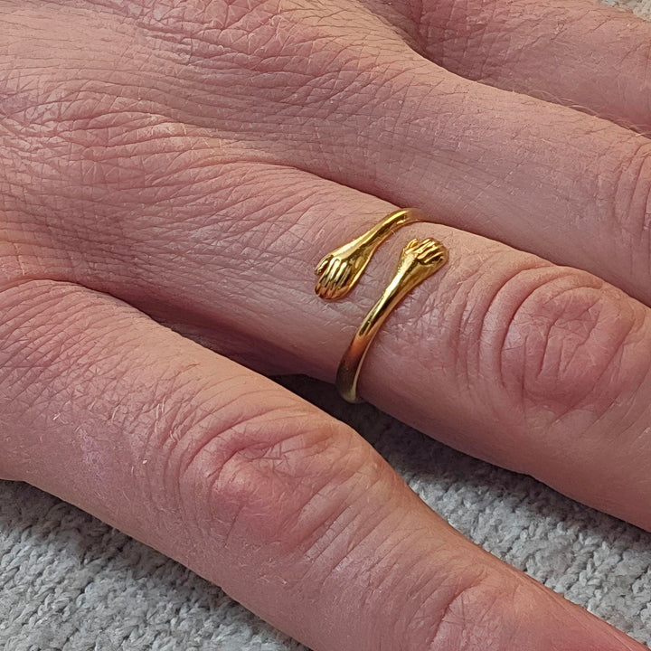 Ring der omfavner i 18 karat forgyldt titanium