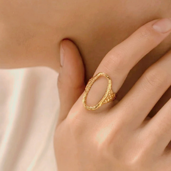 Ring åben og oval med hamret overflade i 18 karat forgyldt titanium