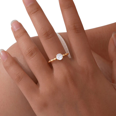 Elegant ring i 18 karat forgyldt rustfrit ædelstål med snoet bånd og zirkon
